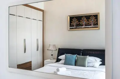 a mirror reflection of a bedroom with a bed at GuestReady - 1BR l Close to Metro Station in Dubai