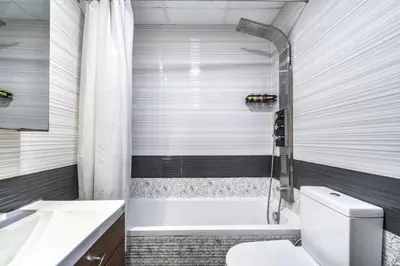 a bathroom with a tub and a toilet and a sink at GuestReady - 1BR l Close to Metro Station in Dubai