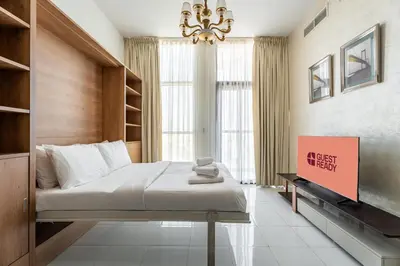 a bedroom with a large bed and a chandelier at GuestReady - 1BR l Close to Metro Station in Dubai