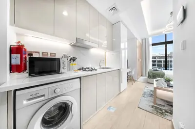 a kitchen with a washer and dryer in a room at StayShort - Studio Apartment at Azizi Riviera with Balcony in Dubai