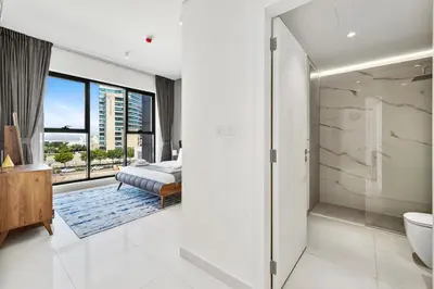a bedroom with a bed and a bathroom with a window at BLVD - Stylish Stay with Relaxing Balcony View in Dubai