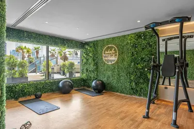 a gym with a green wall with exercise equipment at Full burj Khalifa view chic Studio in Dubai