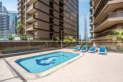 a swimming pool in a building with chairs and a building at Full burj Khalifa view chic Studio in Dubai
