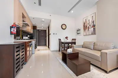 a living room and kitchen with a couch and a table at Full burj Khalifa view chic Studio in Dubai