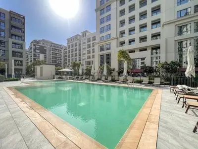 a large swimming pool in the middle of a building at Stylish Dubai Stay 1BR, Lagoon, Pool, Gym in Dubai