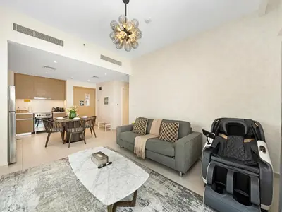 a living room with a couch and a table at Stylish Dubai Stay 1BR, Lagoon, Pool, Gym in Dubai