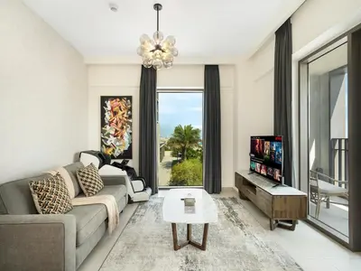 a living room with a couch and a table at Stylish Dubai Stay 1BR, Lagoon, Pool, Gym in Dubai