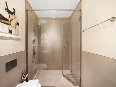 a bathroom with a shower with a glass door at Stylish Dubai Stay 1BR, Lagoon, Pool, Gym in Dubai