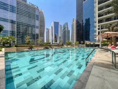 a large swimming pool in a city with tall buildings at GuestReady - 1BR l Canal View in Business Bay in Dubai