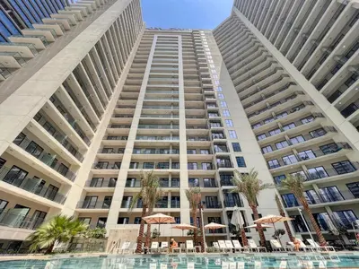 a large building with a pool in front of it at GuestReady - 1BR l Canal View in Business Bay in Dubai