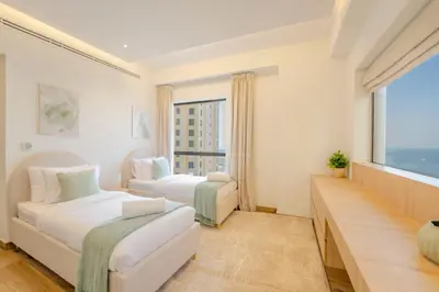 a hotel room with two beds and a large window at EasyGo - Luxury 3BR with Maid's Room, Dubai Eye View, JBR in Dubai