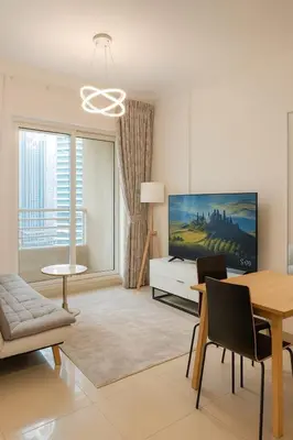 a living room with a dining table and a tv at Marina View Apartment Near JBR Beach & Marina Mall in Dubai