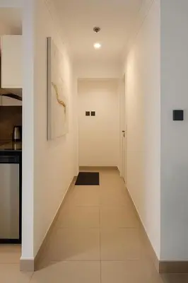 a hallway of a kitchen with white walls and tile floors at Marina View Apartment Near JBR Beach & Marina Mall in Dubai