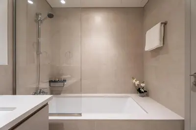 a bathroom with a tub and a glass shower at GuestReady - 1BR | Serene Home in Creek Harbour in Dubai
