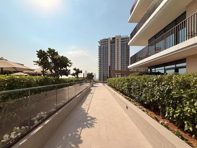 a walkway in front of a building with bushes at GuestReady - 1BR | Serene Home in Creek Harbour in Dubai