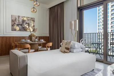 a bedroom with a white bed and a table with chairs at GuestReady - 1BR | Serene Home in Creek Harbour in Dubai