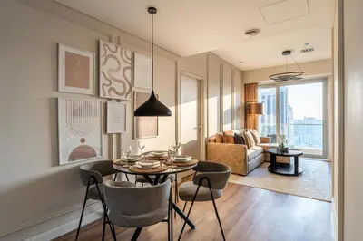a dining room with a table and chairs and a living room at GuestReady - 1BR | High-Floor Skyline Elegance in Dubai