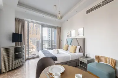 a hotel room with a bed and a table and chairs at Modern Studio with Balcony Orra, Harbour, Marina in Dubai