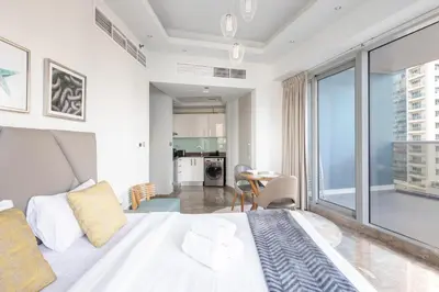 a bedroom with a white bed and a large window at Modern Studio with Balcony Orra, Harbour, Marina in Dubai