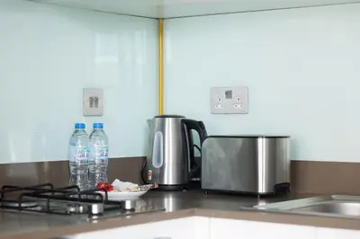 a kitchen counter with two bottles of water and a sink at Modern Studio with Balcony Orra, Harbour, Marina in Dubai