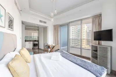 a bedroom with a white bed and a large window at Modern Studio with Balcony Orra, Harbour, Marina in Dubai