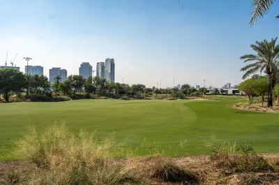 a golf course with the city in the background at GuestReady - Private 4BR Villa | Golf Course View in Dubai