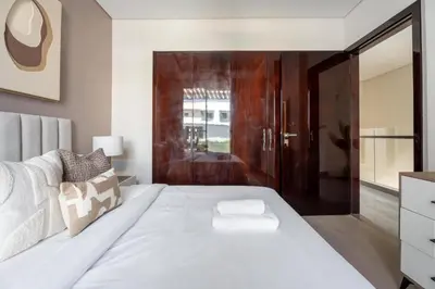 a bedroom with a white bed and a sliding glass door at GuestReady - Private 4BR Villa | Golf Course View in Dubai