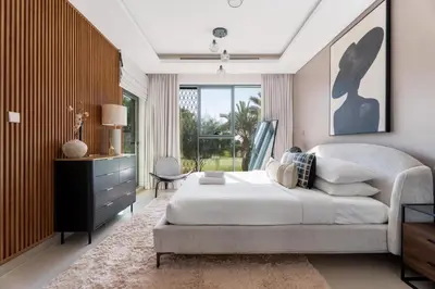 a bedroom with a large bed and a large window at GuestReady - Private 4BR Villa | Golf Course View in Dubai