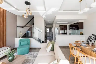 a living room and dining room with a couch and a table at GuestReady - Private 4BR Villa | Golf Course View in Dubai
