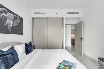 a bedroom with a white bed with blue pillows at 1BR at Beach Isle Tower Emaar Beach front by EE Holiday Homes in Dubai