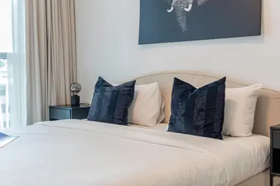 a bedroom with a bed with blue pillows at 1BR at Beach Isle Tower Emaar Beach front by EE Holiday Homes in Dubai