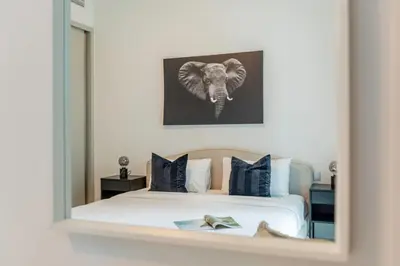 a mirror reflection of a bedroom with an elephant painting on the wall at 1BR at Beach Isle Tower Emaar Beach front by EE Holiday Homes in Dubai