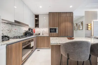 a kitchen with wooden cabinets and a marble counter top at Mahogany 22 - 4BR 16PAX - Burj Khalifa View Central in Dubai