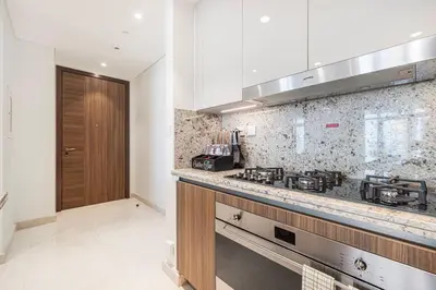 a kitchen with a stove and a counter top at Mahogany 22 - 4BR 16PAX - Burj Khalifa View Central in Dubai
