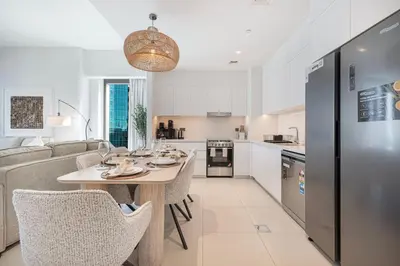 a kitchen and living room with a table and chairs at Mahogany 23 - 2BR 10PAX - Burj Khalifa View Central in Dubai