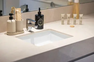 a bathroom sink with a black soap dispenser next to it at Mahogany 23 - 2BR 10PAX - Burj Khalifa View Central in Dubai
