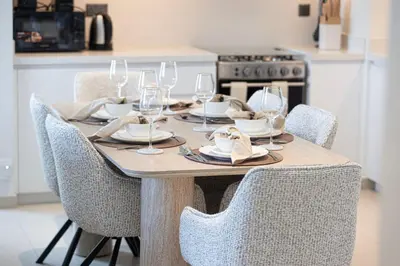 a wooden table with chairs and wine glasses on it at Mahogany 23 - 2BR 10PAX - Burj Khalifa View Central in Dubai