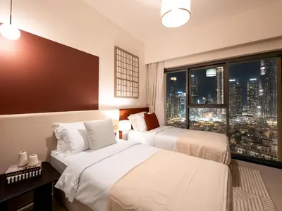 two beds in a hotel room with a view of a city at New-Best Burj Khalifa View I 2BR I Walk DubaiMall in Dubai