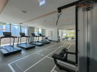 a gym with a row of treadmills and machines at Beach vibes with Serene views in Dubai