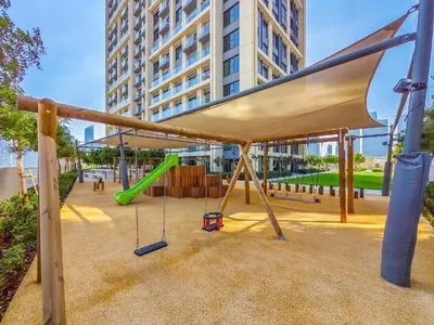 a playground with a green slide in a city at Full Burj Khalifa & Fountain Views - Luxury 2BR in Downtown Dubai in Dubai