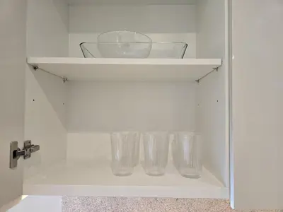 a cupboard with four empty glasses in it at Full Burj Khalifa & Fountain Views - Luxury 2BR in Downtown Dubai in Dubai