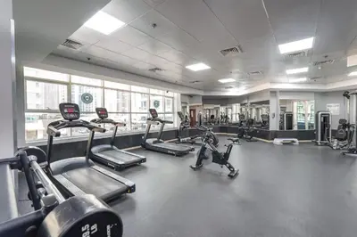 a gym with several treadmills and elliptical machines at ZenStay - Charming Studio in JLT, near JBR &Marina in Dubai