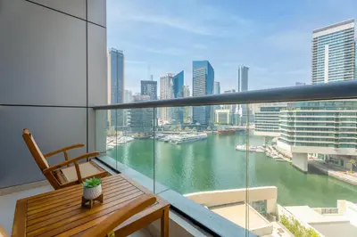 a balcony with a wooden bench and a view of a river at Gala Guests - Luxury Dubai Marina View Apartments - 1 min Walk to Tram in Dubai