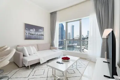 a living room with a white couch and a large window at Gala Guests - Luxury Dubai Marina View Apartments - 1 min Walk to Tram in Dubai