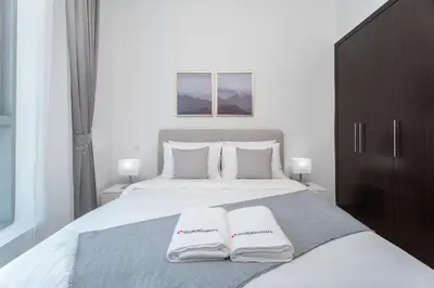 a bedroom with a bed with two white towels on it at Gala Guests - Luxury Dubai Marina View Apartments - 1 min Walk to Tram in Dubai
