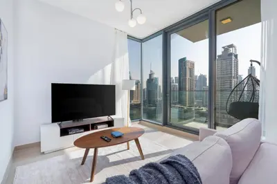 a living room with a couch and a large window at Gala Guests - LIV Contemporary Marina View Apartment Collection in Dubai