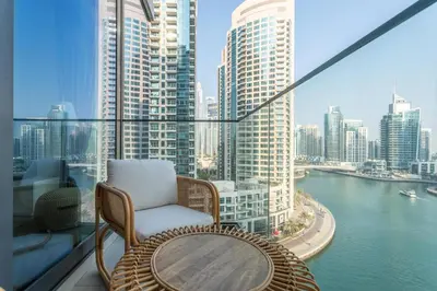a balcony with a chair and a table and a view of a city at Gala Guests - LIV Contemporary Marina View Apartment Collection in Dubai