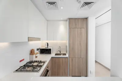 a white kitchen with a stove and a sink at Gala Guests - LIV Contemporary Marina View Apartment Collection in Dubai
