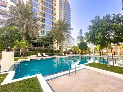 a swimming pool with palm trees and a building at South Ridge By Luxe Living - Full Burj Khalifa View in Dubai
