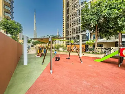 a playground in a city with swings and a slide at South Ridge By Luxe Living - Full Burj Khalifa View in Dubai